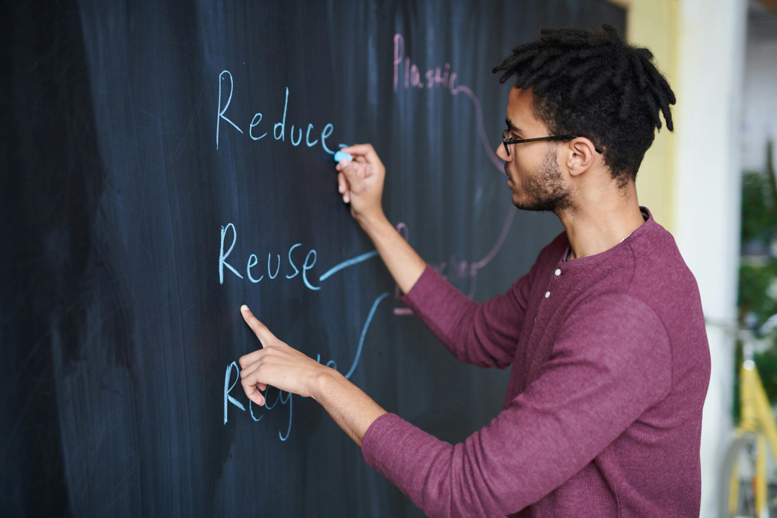 A man writes environmental sustainability strategies on a chalkboard