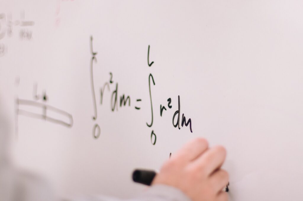 A student solves a calculus problem on a whiteboard.