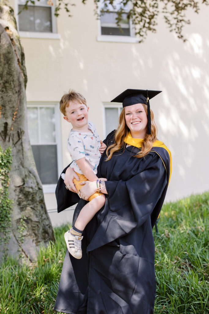 graduate holding proud child