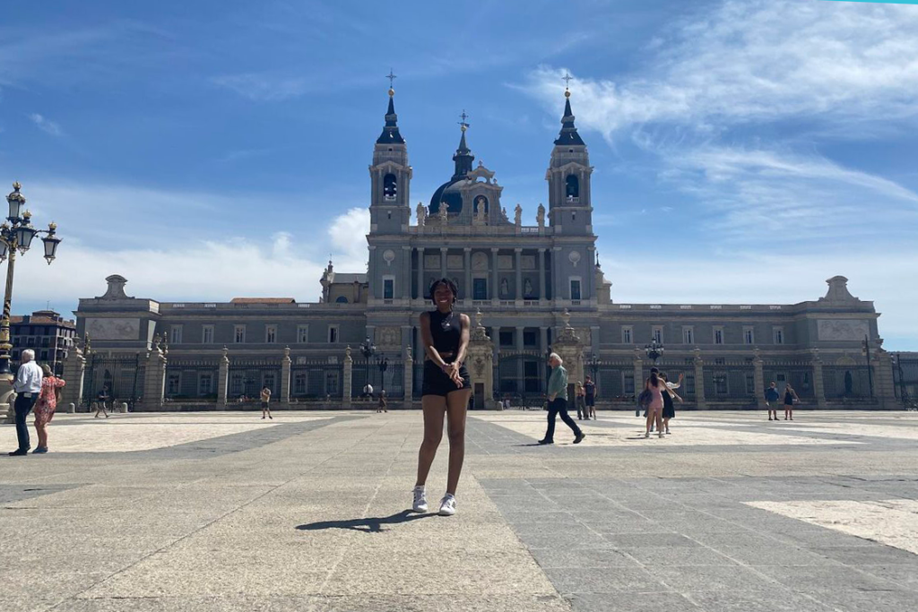 A student stands in front of a religious building on a study abroad trip.