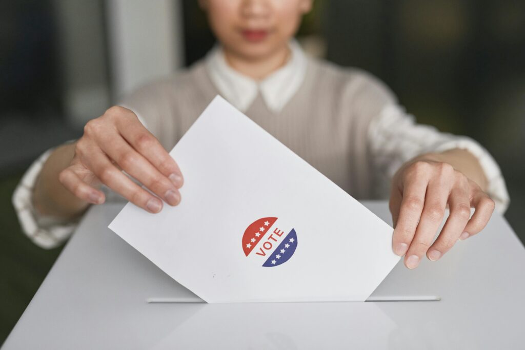 A woman slips a vote into a ballot box.