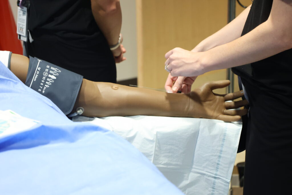 Close-up of medical mannequin arm receiving an IV
