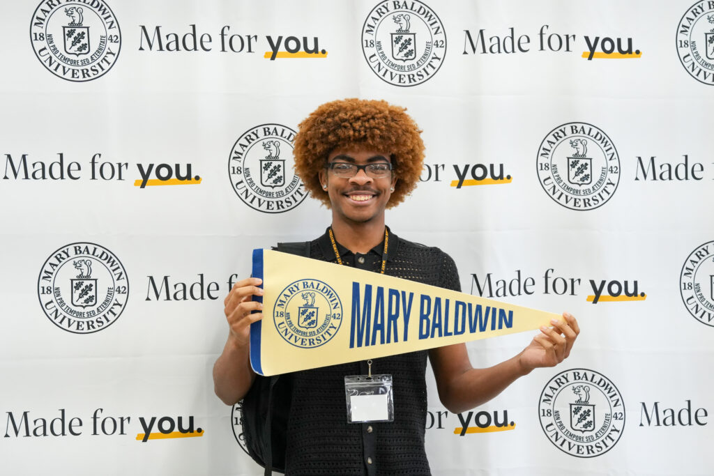 Young man holding Mary Baldwin penant