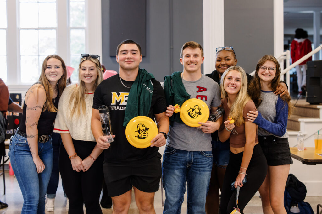 A group of MBU students holding MBU swag