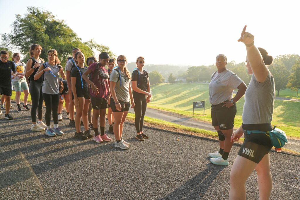 Two VWIL instructors facing a group of young people in athletic clothing