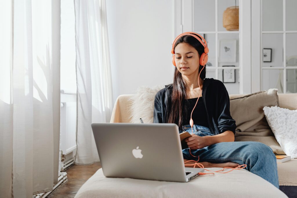 Girl sitting on couch looking at laptop