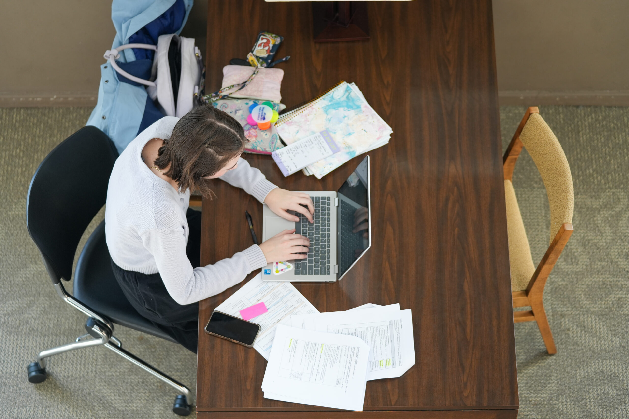 A top-down view of a student studying at a table in Grafton Library