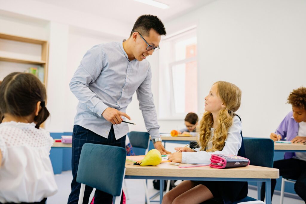 A teacher talks with a student in class