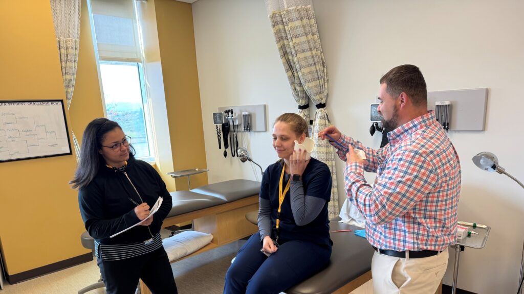 An FNP student learning on a hospital bed