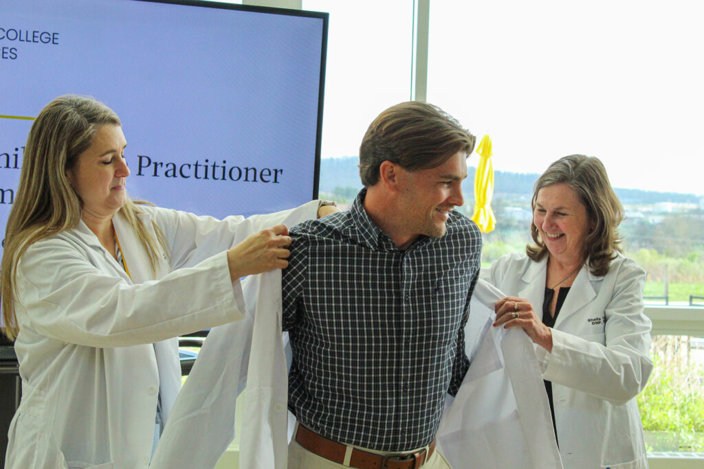 A newly graduated nursing student receives his white coat