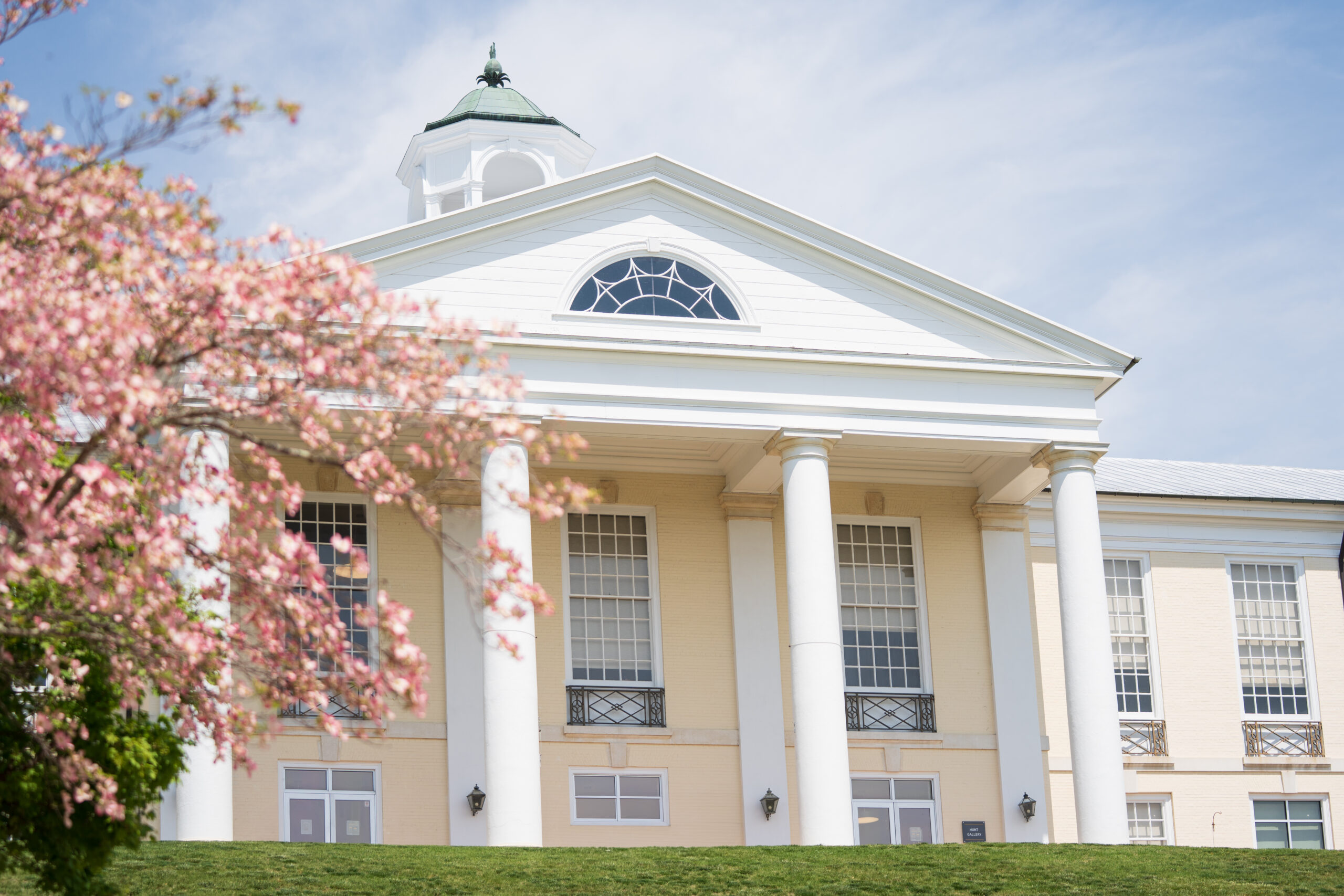 Springtime Image of Hunt Dining Hall, with flowering trees in foreground