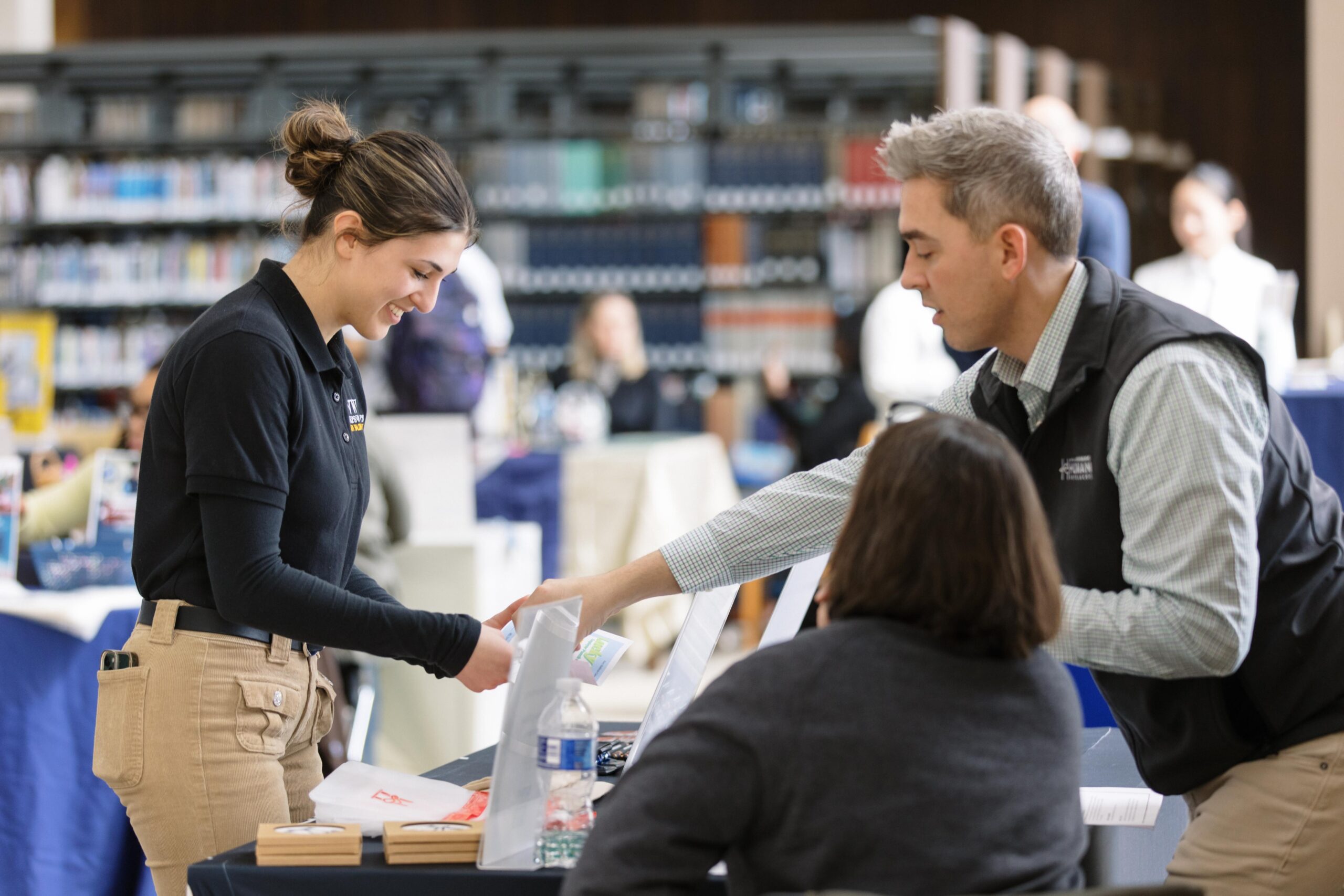 Student asking questions at a career fair table