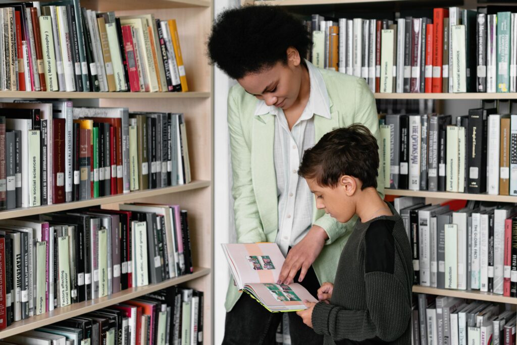 A librarian helps a student read a book
